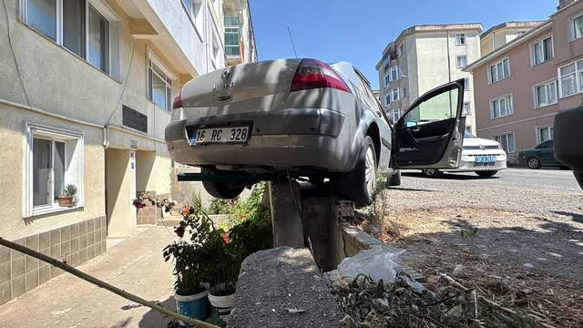 El frenini çekmeyi unuttuğu otomobili istinat duvarında asılı kaldı